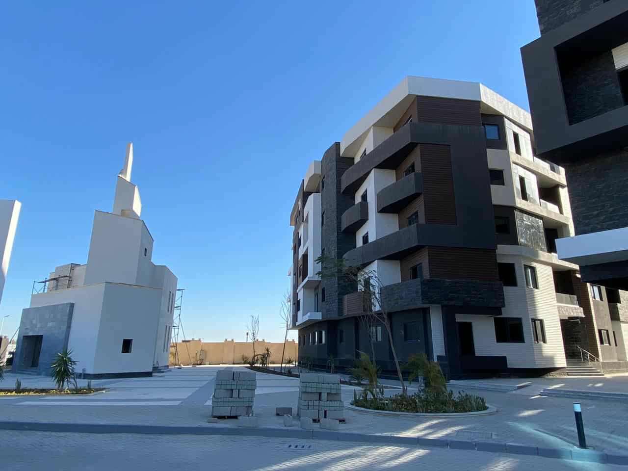 Image of an apartment complex with cars parked in front